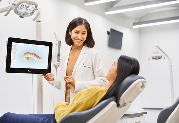 A patient consulting with an orthodontist using the advanced iTero 5D Scanner to visualize dental alignment. Discover the Benefits Of The iTero 5D Scanner at Gramercy Orthodontics in NYC for precise and efficient orthodontic care.