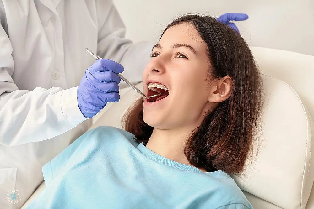an orthodontist examining his patient while explaining how long do braces take in New York, NY