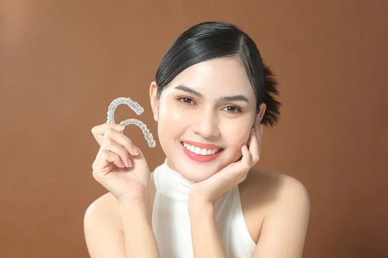 young woman beautiful teeth holding invisalign clear aligners healthy dental - Can Invisalign Fix Overbite in New York, NY.