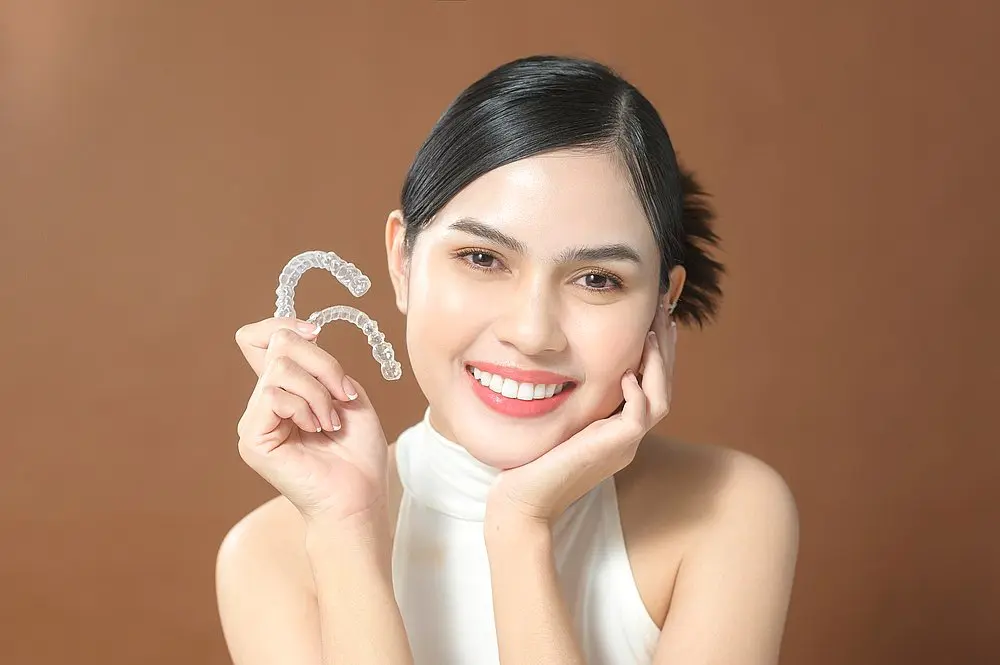 young woman beautiful teeth holding invisalign clear aligners healthy dental - Can Invisalign Fix Overbite in New York, NY.