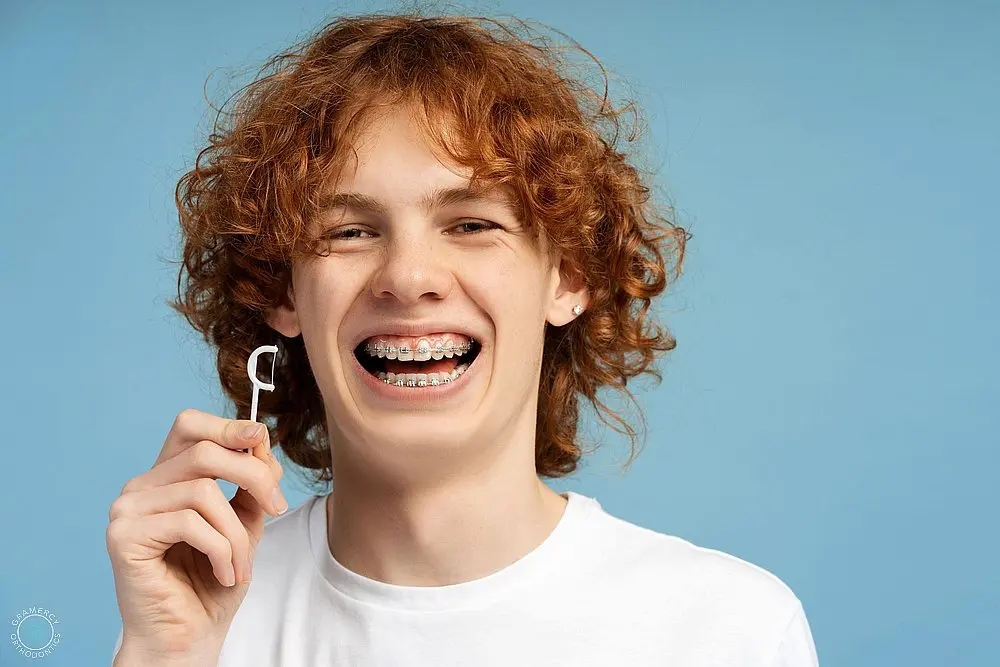 closeup image smiling teenager curly red hair metal braces - How to Floss with Braces in New York, NY