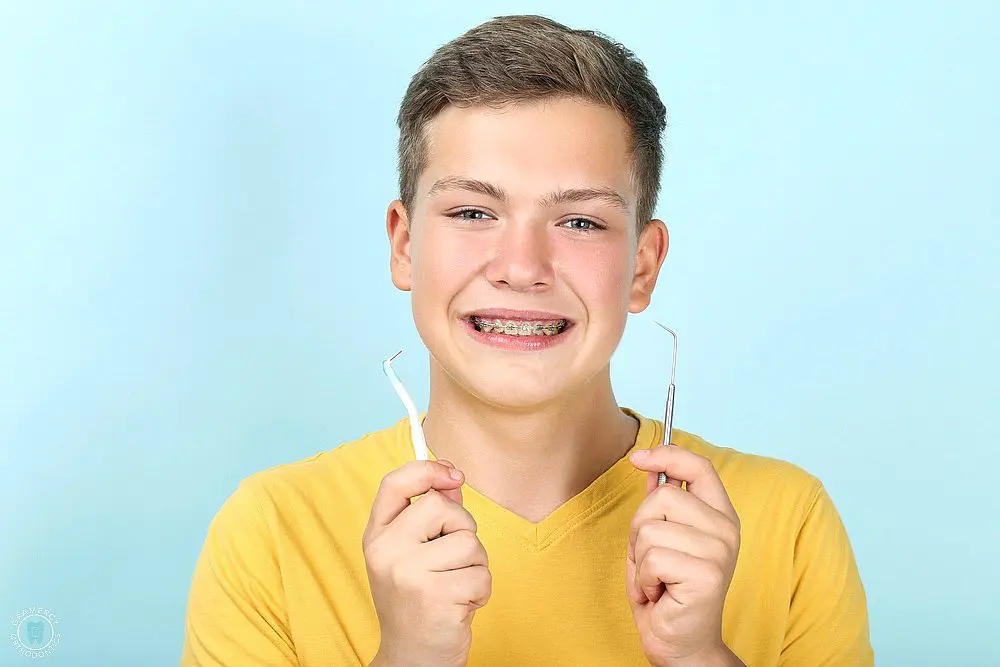 young man with metal braces toothbrush dentist tool - How to Floss with Braces in New York, NY 