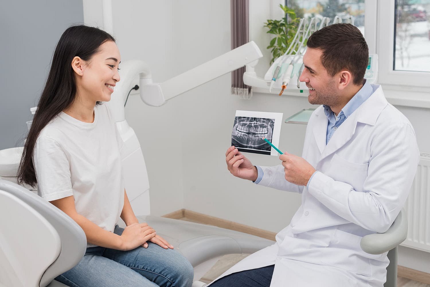 The dentist explains the benefits of a palatal expander as they show a dental X-ray to the smiling patient comfortably seated in the chair in NYC